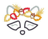 An applique of a raccoon's face wearing a crown of fall leaves and acorns by snugglpuppyapplique.com