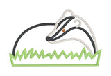An applique of a badger laying in grass by snugglepuppyappllique.com