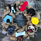 Wreath displaying large fetlies, Doghouse, Boston Terrier, Fire hydrant, Dachshund, tennis ball, Pug, bone, and Schnauzer