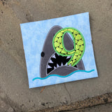 An applique of a shark biting the number nine by snugglepuppyapplique.com