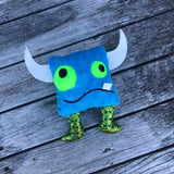 In the hoop Monster stuffy with one tooth, two horns and two legs by snugglepuppyapplique.com