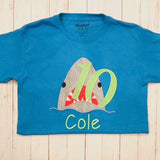 an applique of a shark biting the number 10 by snugglepuppyapplique.com