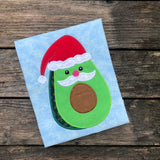 An applique of an avocado with a mustache wearing a santa hat by snugglepuppyapplique.com