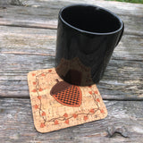 An in the hoop Autumn Coaster with an Acorn in the center and a boarder of twigs and fall leaves by snugglepuppyapplique.com