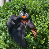 An In the hoop embroidery design of a crow's head with ribbon feather attached to a small blanket by snugglepuppyapplique.com