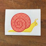 An applique of a garden snail by snugglepuppyapplique.com