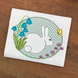a bean stitch applique of a wild rabbit surrounded by flowers and a butterfly by snugglepuppyapplique.com
