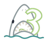 An applique of a shark biting the number 3 by snugglepuppyapplique.com