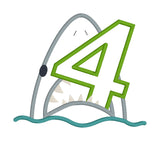 An applique of a shark biting the number 4 by snugglepuppyapplique.com