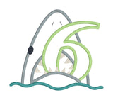 An applique of a shark biting the number 6 by snugglepuppyapplique.com