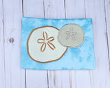 An appliqué of two sand dollars by snugglepuppyapplique.com