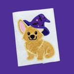 An appliqué of a Welsh Corgi wearing a wizard or witches hat over one ear by snugglepuppyapplique.com