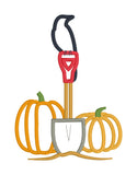 a applique design of a crow perched on the handle of a shovel between two pumpkins by snugglepuppyapplique.com