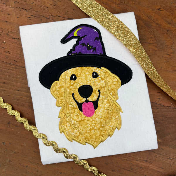 An applique design of a golden retriever wearing a witch or wizards hat by snugglepuppyapplique.com