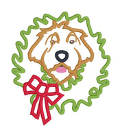 An applique design of a Wirehaired Pointing Griffon hunting dog with its head through a Christmas Wreath by snugglepuppyapplique.com