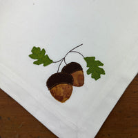 A bean stitch applique of two acorns and two leaves by snugglepuppyapplique.com