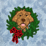 An applique design of a Wirehaired Pointing Griffon  hunting dog with its head through a Christmas  Wreath by snugglepuppyapplique.com