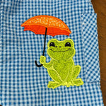 An applique of a frog holding an open umbrella by snugglepuppyapplique.com