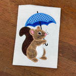 an applique of a squirrel holding a umbrella by snugglepuppyapplique.com