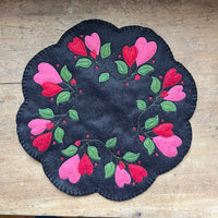 A candle mat made from wool with an embroidery file by snugglepuppyapplique.com