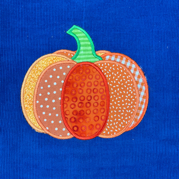 An appliqué of a pumpkin in patchwork  by snugglepuppyapplique.com