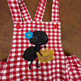 An applique of an ant carrying a picnic basket with a flower tucked behind her ear by snugglepuppyapplique.com