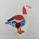 A zigzag applique of a patchwork goose in red, white and blue by snugglepuppyapplique.com