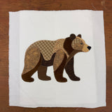 An applique of a bear in patchwork by snugglepuppyapplique.com
