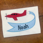 An applique of an airplane pulling a banner by snugglepuppyapplique.com
