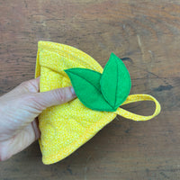 An in the hoop quilted Lemon shaped potholder with a pocket for your hand by snugglepuppyapplique.com