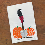 a applique design of a crow perched on the handle of a shovel between two pumpkins by snugglepuppyapplique.com