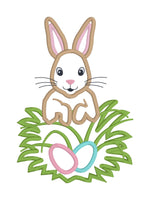 An applique design of a rabbit and eggs in the grass