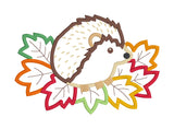An applique design of a hedgehog sitting on autumn leaves by snugglepuppqappliqe.com