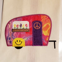 An applique of a camper with a piece sign on the door, smiley face on the fender and flowers spelling "peace" by snugglepuppyapplique.com