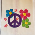 An applique of the peace symbol and flowers by snugglepuppyapplique.com