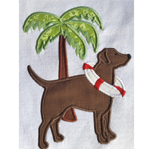 An applique of a Labrador with a life ring around its' neck and a palm tree behind it. snugglepuppyapplique.com
