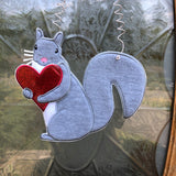 An in the hoop squirrel holding a heart door hanger embroidery design by www.snugglepuppyapplique.com