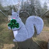 An in the hoop squirrel holding a clover door hanger embroidery design by www.snugglepuppyapplique.com