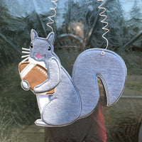 An in the hoop squirrel holding a football door hanger embroidery design by www.snugglepuppyapplique.com