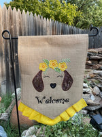 A garden flag of an applique dachshund wearing a floral crown by snugglepuppyapplique.com