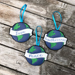 Set of 4 Earth Christmas ornaments each with a banner one has "love" one has "peace" and one has "togetherness" embroidered on the banner.  by snugglepuppyapplique.com