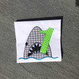 An applique of a shark biting the number one by snugglepuppyapplique.com