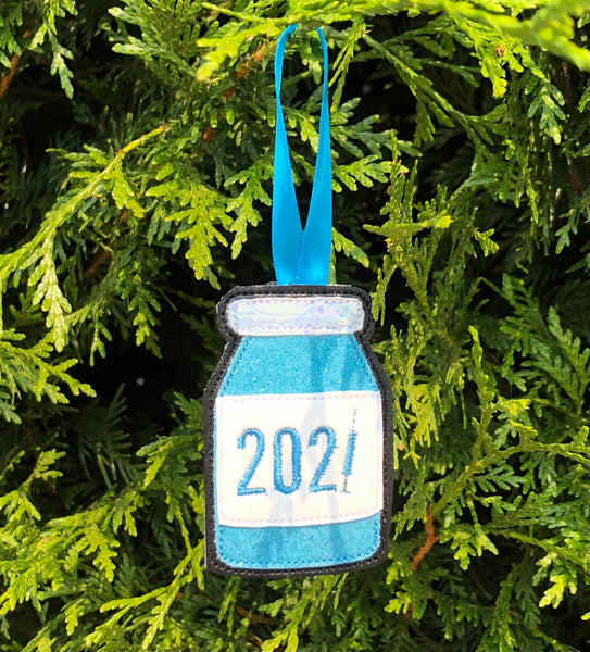 An in the hoop ornament of a vial with the word 2021 embroidered on it. the "1" is a syringe. by snugglepuppyapplique.com
