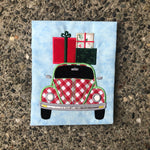 An applique of a bug car with presents on the roof by snugglepuppyapplique.com