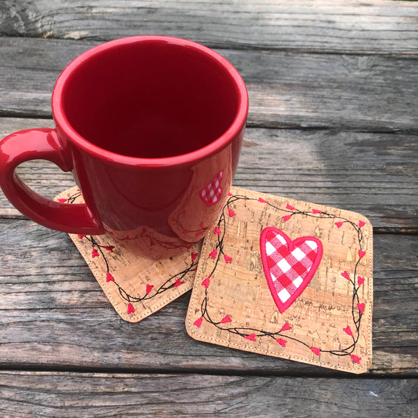 An in the hoop Valentine Coaster with a heart in the center and a vine boarder with heart shaped flowers by snugglepuppyapplique.com