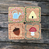 Four in the hoop Coasters one of a watering can with  a tulip border, one of a bee hive with an ivy border, one of an acorn with a fall leave border and one of a mushroom with an evergreen border by snugglepuppyapplique.com