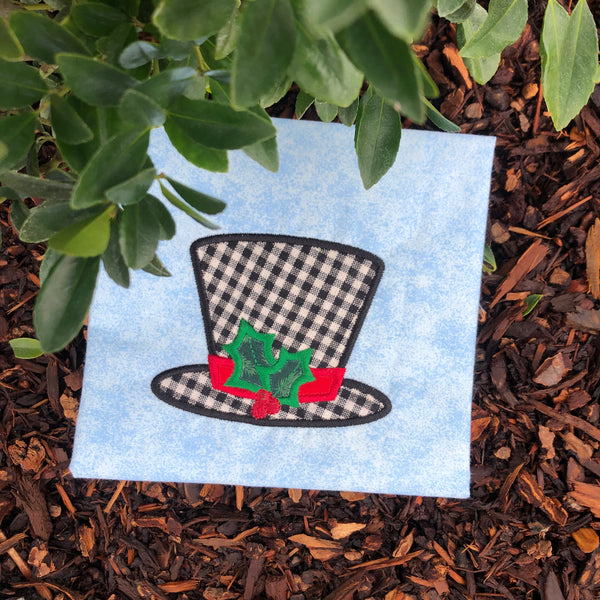 An applique of a top hat with holly by snugglepuppyapplique.com