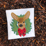 An applique of a Mule Deer with her head through a Christmas Wreath by Snugglepuppyappliique.com