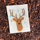an applique of a Buck with christmas lights tangled in his antlers by snugglepuppyapplique.com