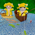 in the hoop kitties with raincoats, hats, and fishing baskets  and a boat with fishing poles and fish embroidery design by snugglepuppyapplique.com